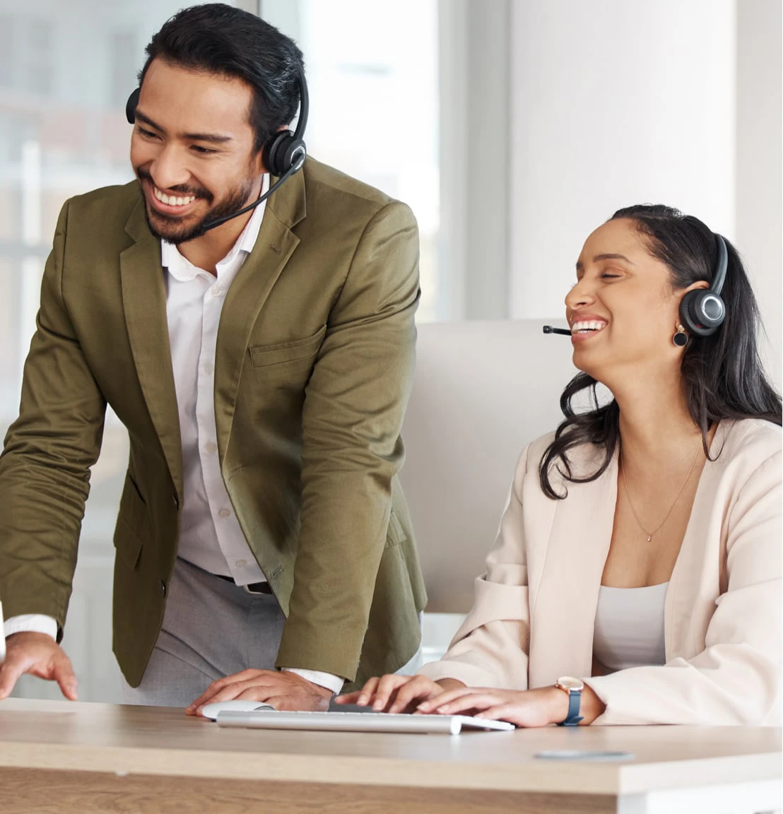 Zwei lachende Personen mit Kopfhörern und Mikrofon